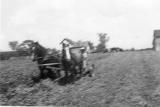 Philip Behselich mowing hay west of the house grainery is on the right.jpg